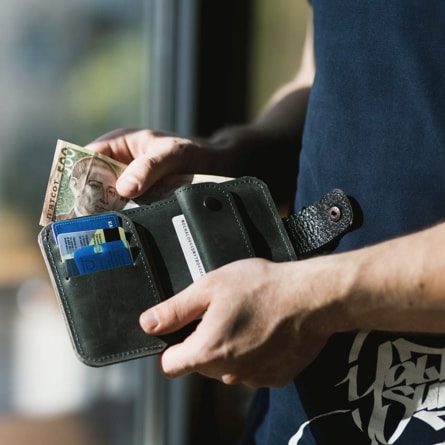 Person holding their wallet taking out cash